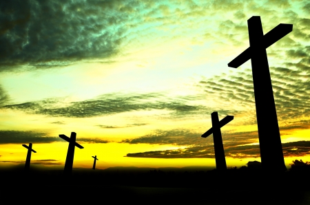 Crosses silhouette in the top of a mountain at sunsetの写真素材