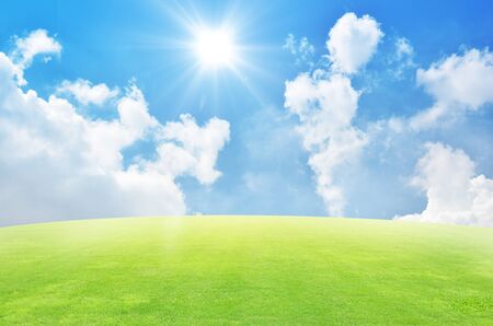 Green field and sky blue with white cloud backgroundの写真素材