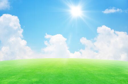 Green field and sky blue with white cloud backgroundの写真素材