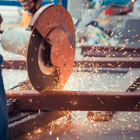 cutting steel with machine for cutting steel by workerの写真素材