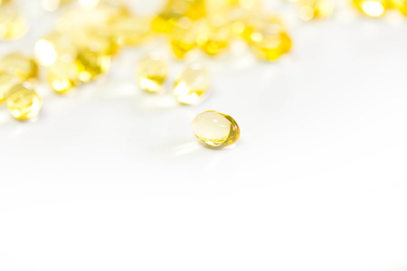 Omega 3 fish oil capsules out open container on white backgroundの写真素材