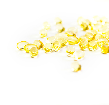 Omega 3 fish oil capsules out open container on white backgroundの写真素材