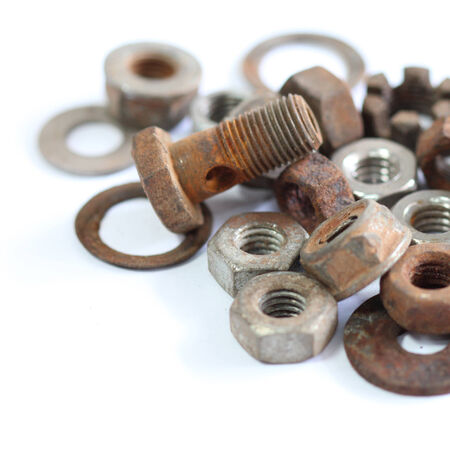group of old rusty nuts and bolts isolated on white backgroundの写真素材