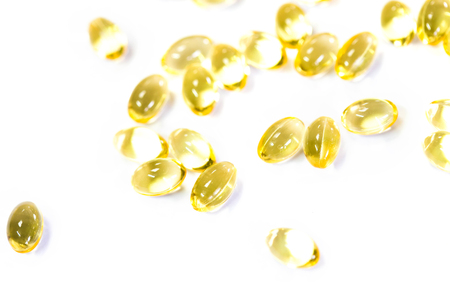 Omega 3 fish oil capsules out open container on white backgroundの写真素材
