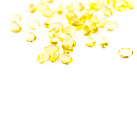 Omega 3 fish oil capsules out open container on white backgroundの写真素材
