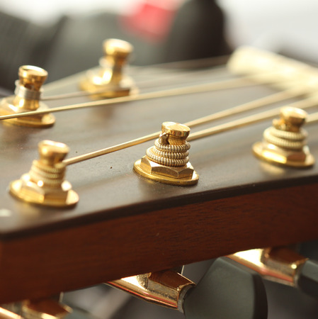 Close up of tuning peg on acoustic guitar headstock