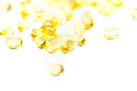 Omega 3 fish oil capsules out open container on white backgroundの写真素材