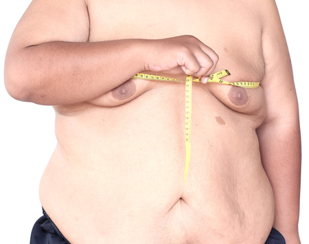 Fat man holding a measurement tapeの写真素材