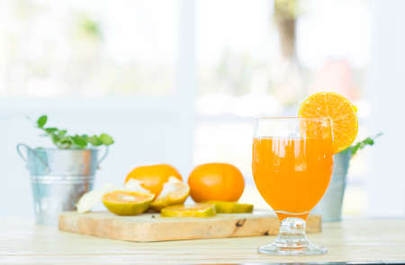 Orange juice in glass , fresh fruits on wooden backgroundの写真素材