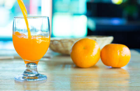 Orange juice in glass , fresh fruits on wooden backgroundの写真素材