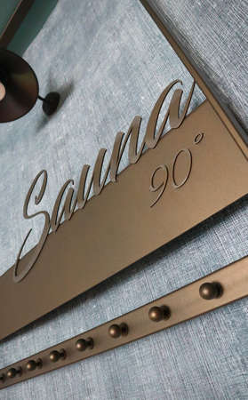 Sauna volumetric lettering decoration inscription at the spa hotel. Entrance sign Sauna title type at the wellness center, closeup.の写真素材