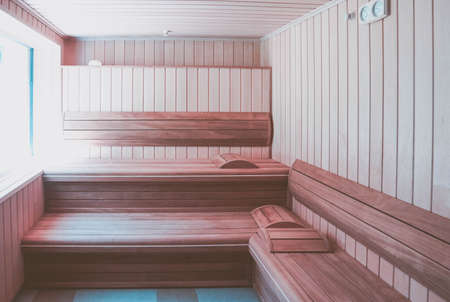 Luxury wooden Bathhouse with a window, sunlight. Elegant sunny wooden sauna interior with a window.の写真素材