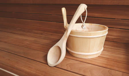 Wooden Bathhouse with scoop and tub tools close up. Wooden sauna interior with equipment.の写真素材