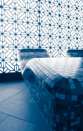 Tepidarium warm relaxing benches decorated with mosaic at the spa hotel. Tepidarium therapy room interior, wellness center.の写真素材