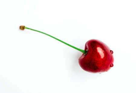 Colorful delicious one single cherry isolated on background, water drops. Top view, natural shadow.の写真素材