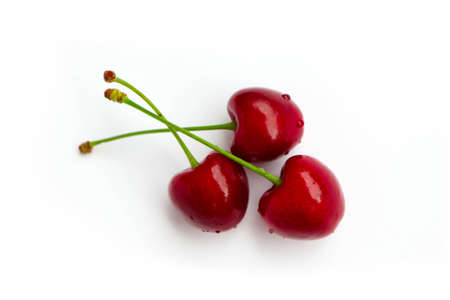 Colorful three delicious cherries isolated on background, water drops. Top view, natural shadow.の写真素材