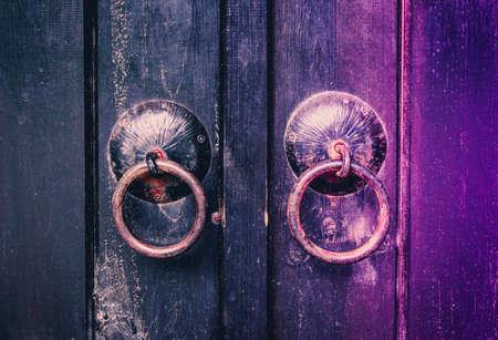 Old wooden door with iron ring handles.の写真素材