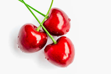Colorful three delicious cherries isolated on background, water drops. Top view, natural shadow.の写真素材