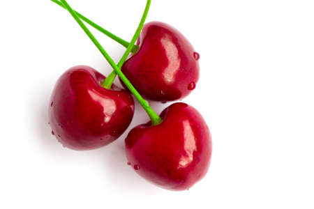 Colorful three delicious cherries isolated on background, water drops. Top view, natural shadow.の写真素材