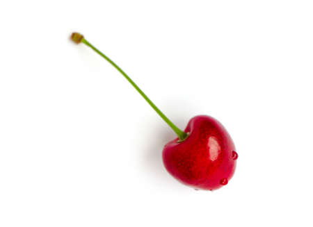 Colorful delicious one single cherry isolated on background, water drops. Top view, natural shadow.の写真素材
