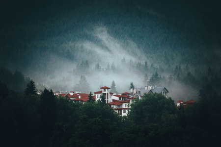 A scary abandoned hotel in the foggy forest. A mystical house in the mountain landscape.の写真素材