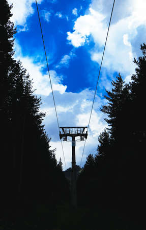 Steel cable way tower construction, blue sky on the background. A mountain rope way transportation part of the ski and snowboarding resort.の写真素材