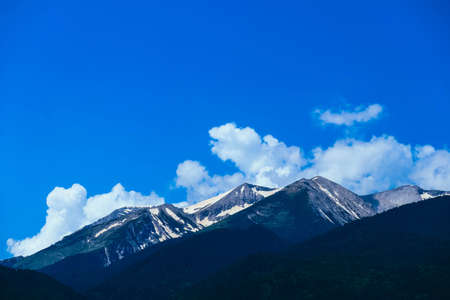 Beautiful alpine ice mountains peaks with snow, summer time, blue sky background.の写真素材