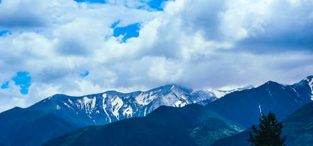 Beautiful alpine ice mountains peaks with snow, summer time, blue sky background.