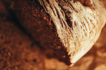 A piece of handmade freshly baked rye bread, texture background, closeup.