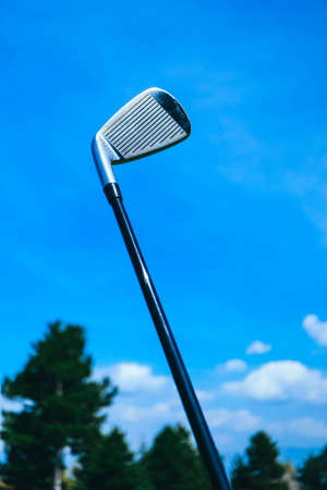 Golf stick on a blue sky and pine trees background, close up view.の写真素材