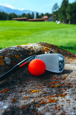 Golf stick and a red bright ball on a golf course, close up. Luxury sport concept.の写真素材