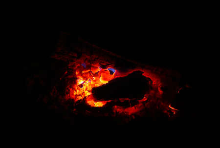 Colorful flame, burning wood at the fireplace. Firewood brick at the fire, closeup.の写真素材