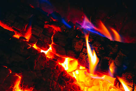 Colorful fire flame, burning wood at the fireplace. Firewood log in the fire chimney, closeup.の写真素材