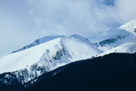 Mountain snow peak, beautiful natural winter backdrop. Ice top of the hill, blue sky background. Alpine landscape.の写真素材