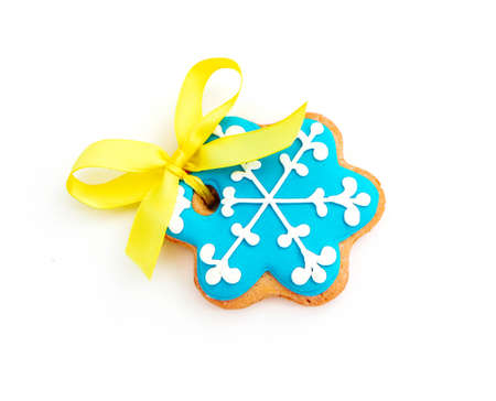 Cookie in a shape of blue snowflake with ribbon, isolated on white background. Christmas holiday decoration, winter time food.の写真素材