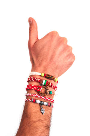 Bulgarian traditional spring decor bracelet martenitsa, pointing male hand. Baba Marta holiday, thumb up finger gesture, backdrop.の写真素材