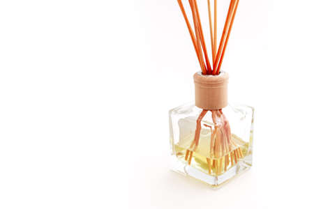 Home perfume in a glass bottle with wooden sticks, isolated on white background. Elegant spa decoration, luxury air fresher, Asian style.の写真素材