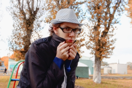 young man in a hat and glasses on the streetの写真素材