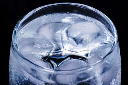 Glass of water with ice on a black background