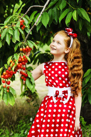 Girl in a beautiful dress in cherry gardenの写真素材