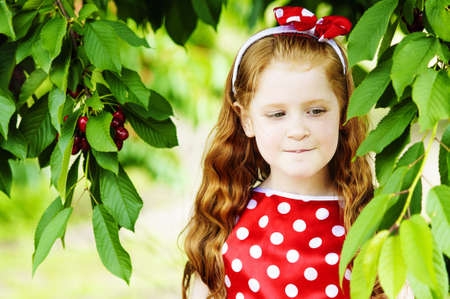 girl in a beautiful dress in cherry gardenの写真素材