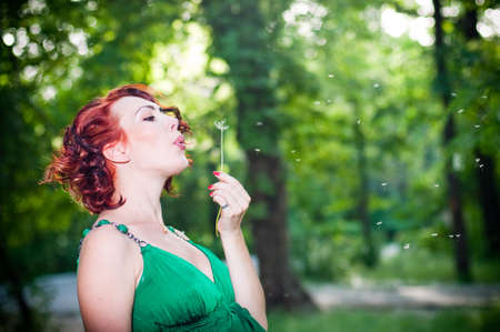 Young pregnant woman in a green dress in the gardenの写真素材