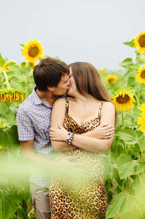 Young girl and a young man in the field of sunflowersの写真素材