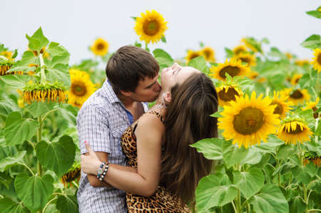 Young girl and a young man in the field of sunflowersの写真素材