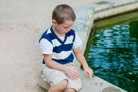 boy playing by the fountainの写真素材