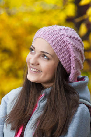 Young girl in a park in autumn with yellow leaves