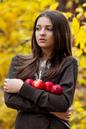 Young girl in autumn park with applesの写真素材