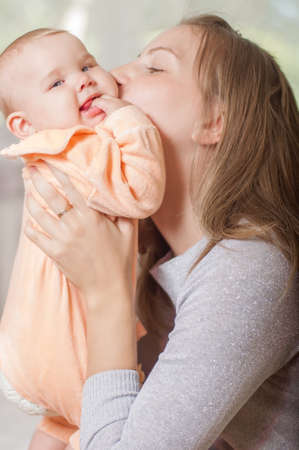 young mother holding a baby at home