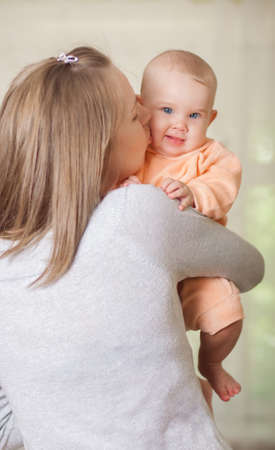 young mother holding a baby at homeの写真素材