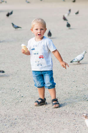 Little boy eating ice cream in the park in summer